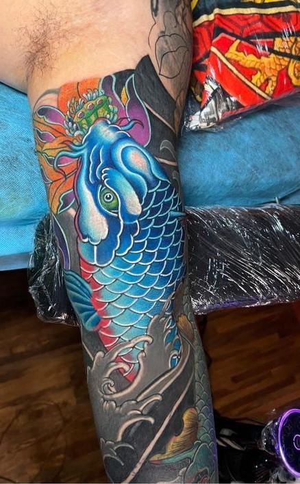 Tattoo cá chép xanh và hoa sen ở bắp tay