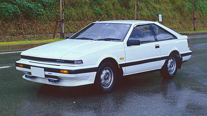 Side view of a two-door car with wing mirrors